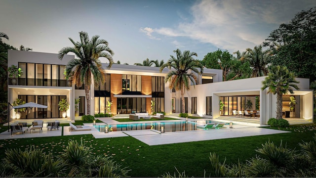 back of house with stucco siding, a lawn, a patio, an outdoor pool, and an outdoor hangout area