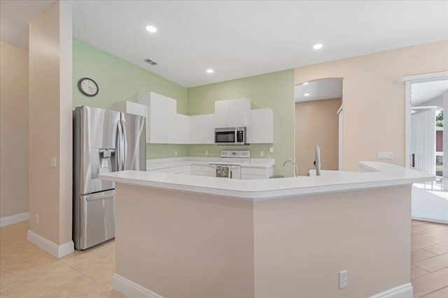 kitchen featuring appliances with stainless steel finishes, a center island with sink, white cabinets, light tile patterned floors, and sink