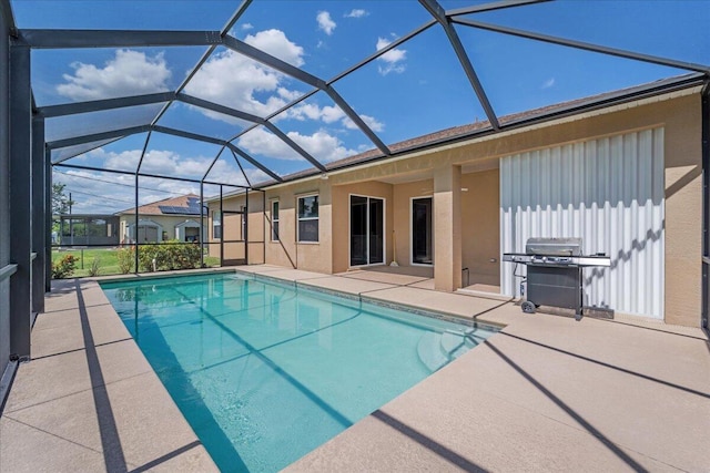 view of pool featuring glass enclosure, a grill, and a patio area