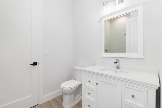 bathroom with hardwood / wood-style flooring, vanity, and toilet