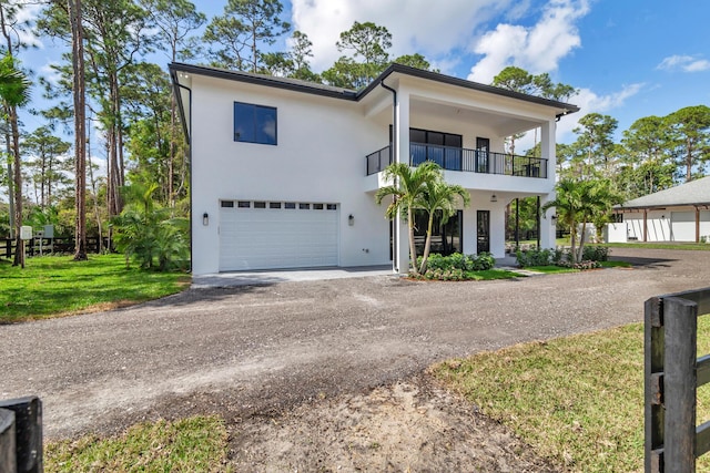 view of front facade with a garage, a balcony, and a front lawn