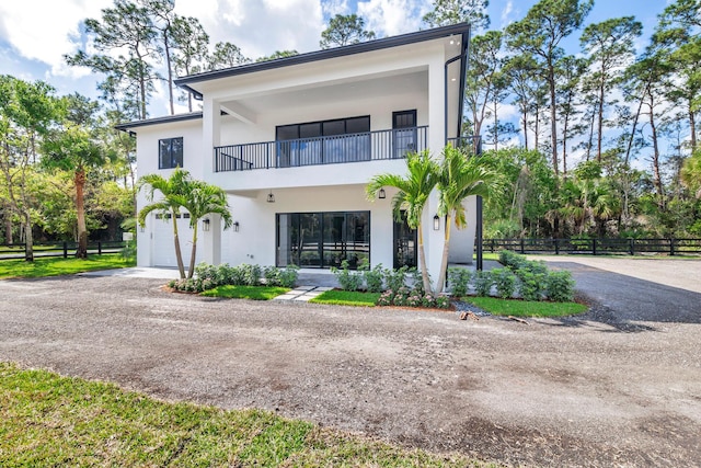 contemporary house featuring a garage and a balcony