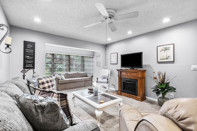 carpeted living room featuring ceiling fan and a textured ceiling