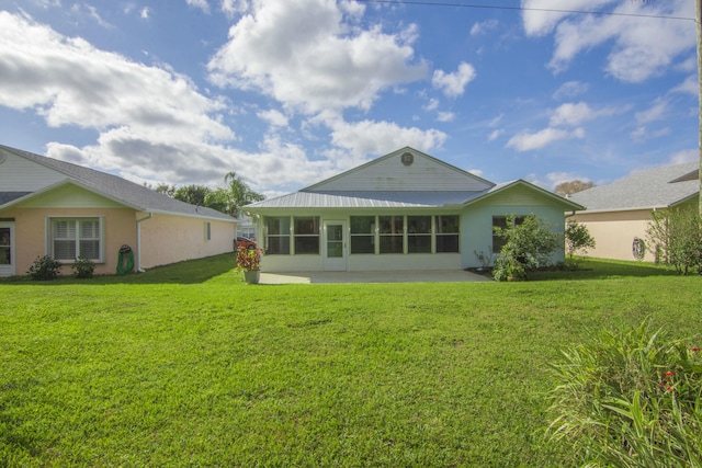 back of property with a yard and a patio area