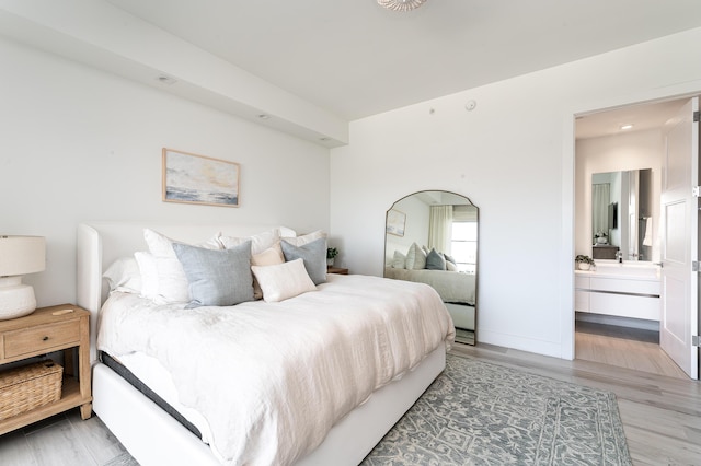 bedroom featuring ensuite bathroom and hardwood / wood-style floors