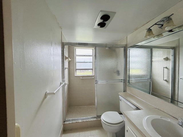 bathroom with toilet, a shower stall, vanity, and tile patterned floors