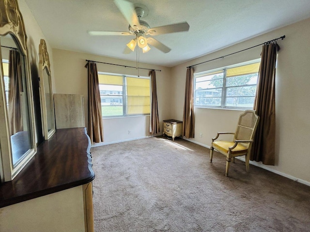 unfurnished room featuring carpet floors, baseboards, and a ceiling fan