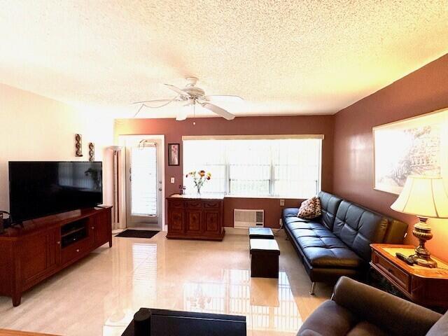 living room featuring a textured ceiling and ceiling fan