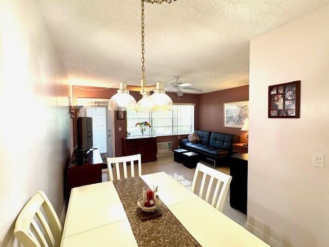 dining room featuring a ceiling fan, a textured ceiling, and baseboards