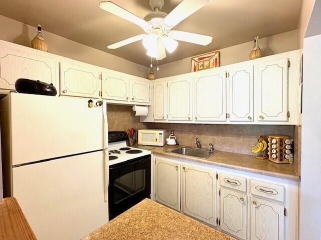 kitchen with tasteful backsplash, light countertops, a sink, ceiling fan, and white appliances