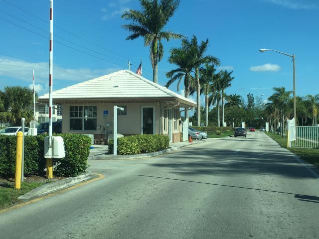 view of street with curbs, street lighting, and a gated entry