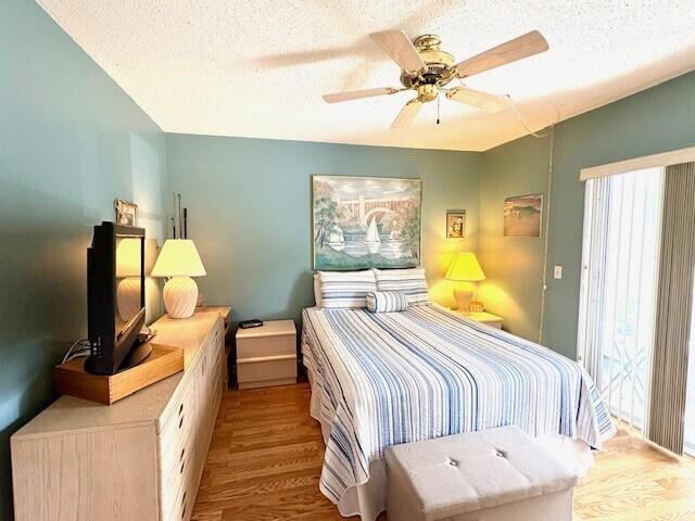 bedroom featuring ceiling fan, a textured ceiling, and wood finished floors