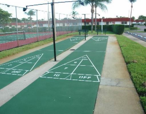 view of home's community with fence and shuffleboard