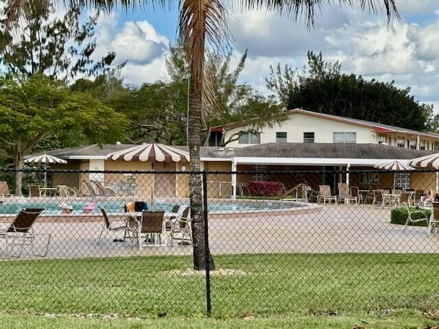 exterior space featuring a yard, a patio, fence, and a pool