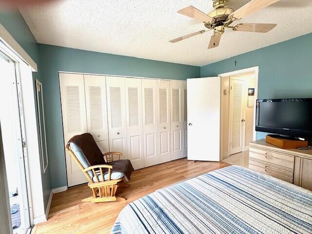 bedroom featuring a closet, light wood-style flooring, and a textured ceiling