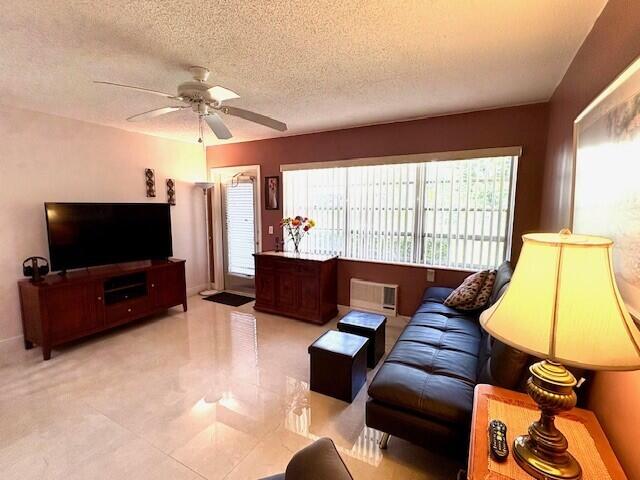 living area with plenty of natural light, a ceiling fan, and a textured ceiling