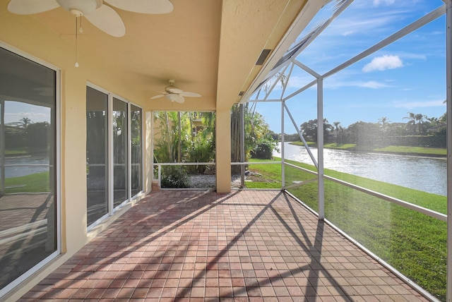 unfurnished sunroom featuring a water view and ceiling fan