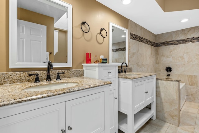 bathroom featuring two vanities, a sink, and recessed lighting