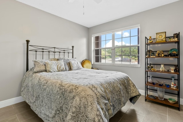 tiled bedroom featuring ceiling fan and baseboards