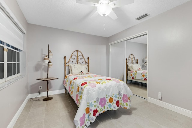 bedroom featuring baseboards, a textured ceiling, visible vents, and a closet