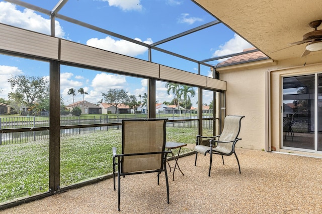 unfurnished sunroom featuring ceiling fan