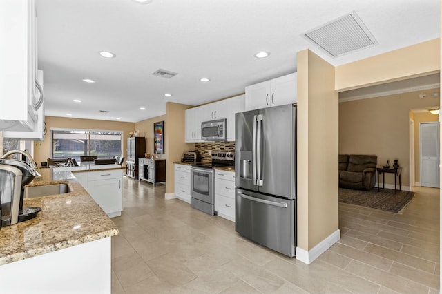 kitchen featuring visible vents, appliances with stainless steel finishes, white cabinets, and a sink