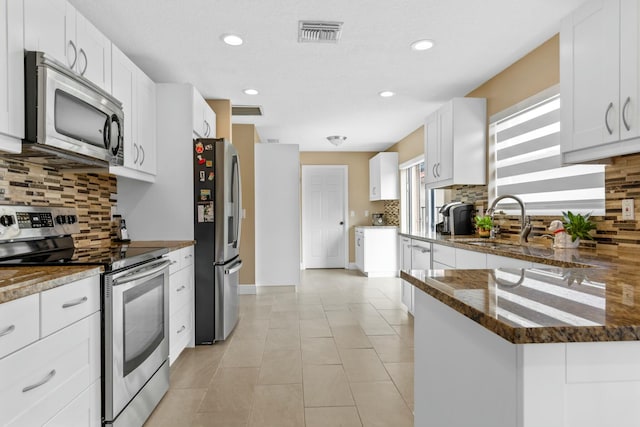 kitchen featuring light tile patterned floors, visible vents, white cabinetry, appliances with stainless steel finishes, and backsplash