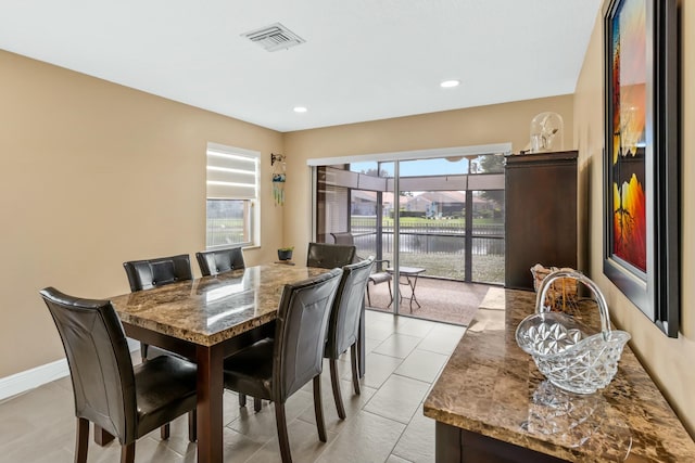 dining area with recessed lighting, visible vents, a water view, and baseboards