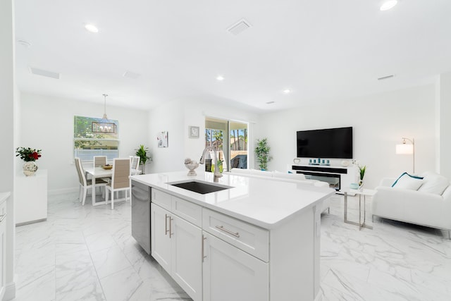 kitchen with a kitchen island with sink, decorative light fixtures, sink, dishwasher, and white cabinets