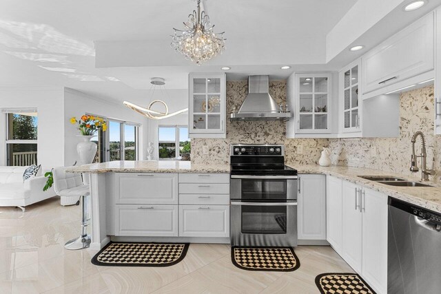 875 E Camino Real Unit 7E, Boca Raton, FL 33432 - kitchen with appliances with stainless steel finishes, sink, white cabinetry, and wall chimney range hood