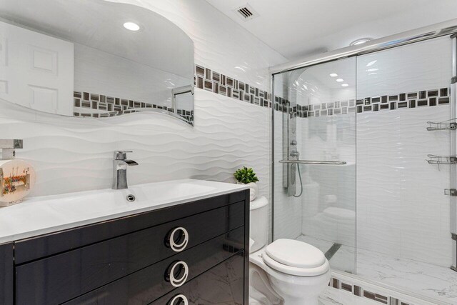 875 E Camino Real Unit 7E, Boca Raton, FL 33432 - bathroom featuring toilet, tile walls, an enclosed shower, and vanity