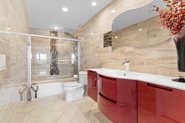 875 E Camino Real Unit 7E, Boca Raton, FL 33432 - full bathroom featuring tile walls, shower / bath combination with glass door, vanity, and toilet