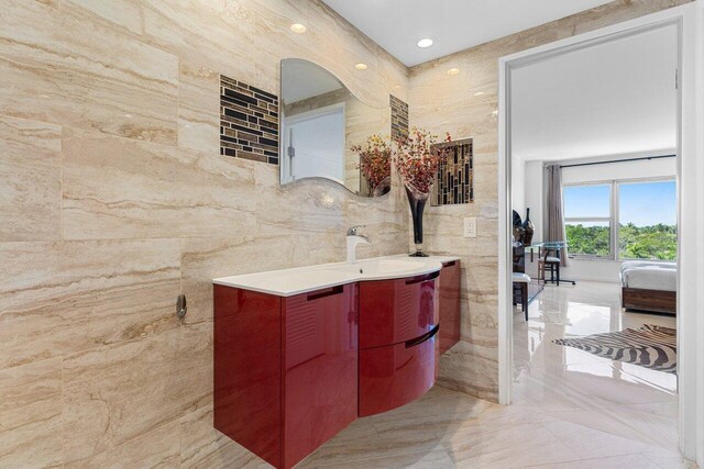 875 E Camino Real Unit 7E, Boca Raton, FL 33432 - bathroom featuring tile walls and vanity