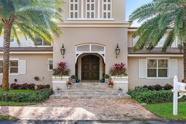 entrance to property featuring stucco siding