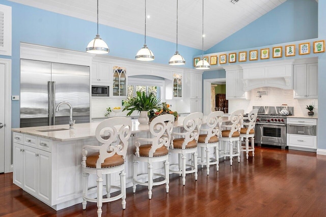 kitchen featuring white cabinets, glass insert cabinets, pendant lighting, and a sink