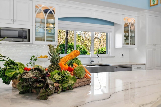 interior space featuring a sink, appliances with stainless steel finishes, tasteful backsplash, and marble finish floor