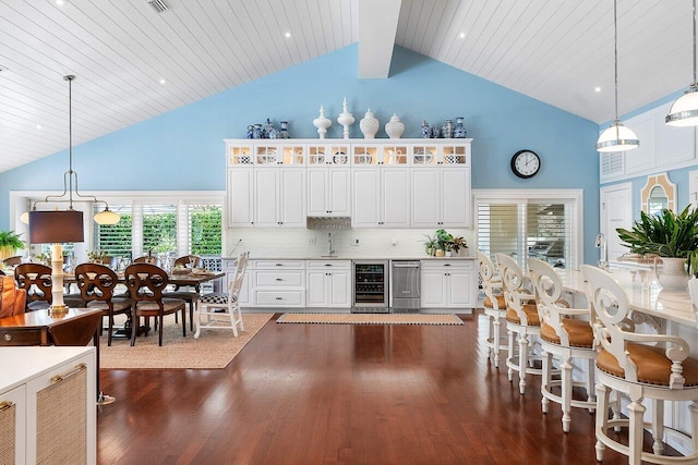 kitchen featuring white cabinetry, hanging light fixtures, and beverage cooler