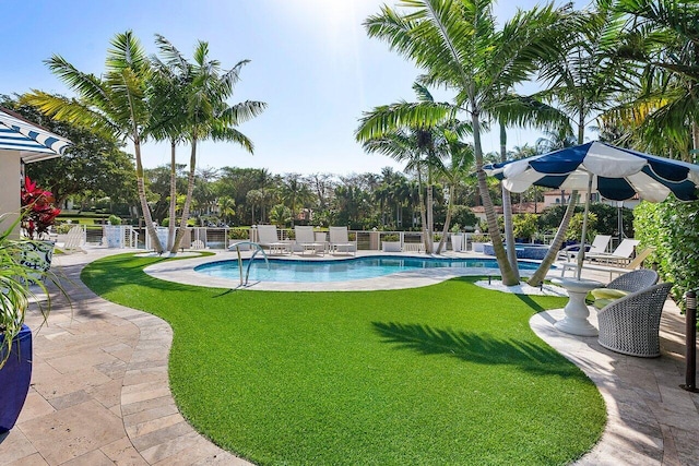 pool with fence, a lawn, and a patio area