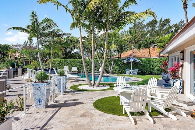 view of patio with a fire pit and a fenced in pool