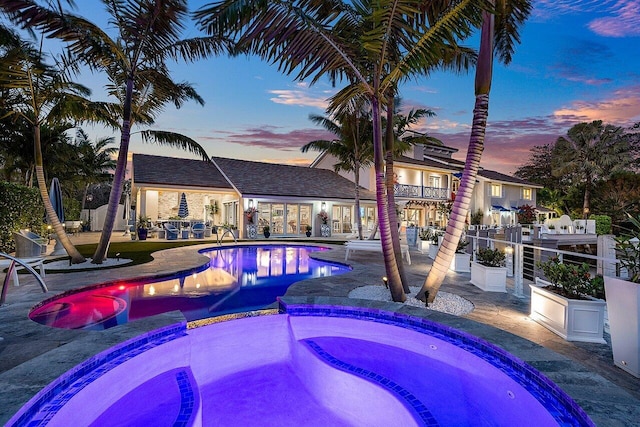 view of pool with a pool with connected hot tub