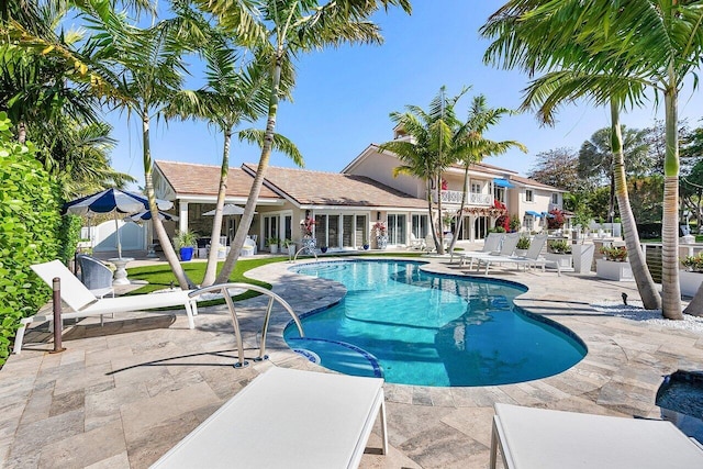 pool with a hot tub and a patio