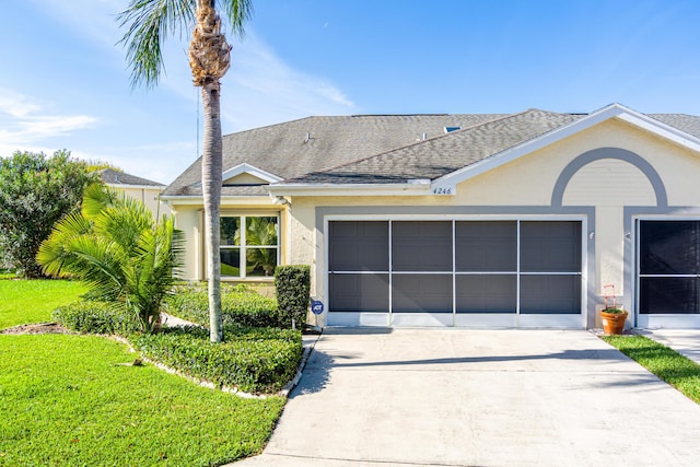 single story home with stucco siding, driveway, roof with shingles, a front yard, and an attached garage