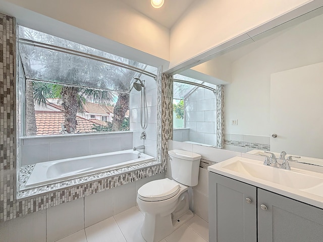 full bathroom featuring tiled tub, vanity, toilet, and tile patterned floors