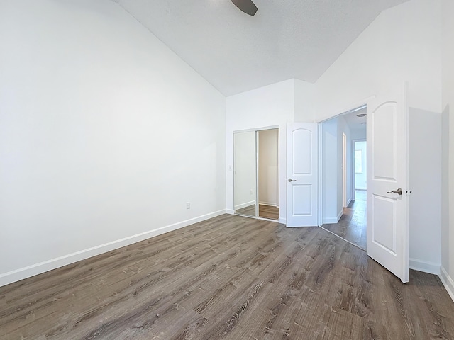 unfurnished bedroom featuring vaulted ceiling, ceiling fan, dark wood-style floors, and baseboards