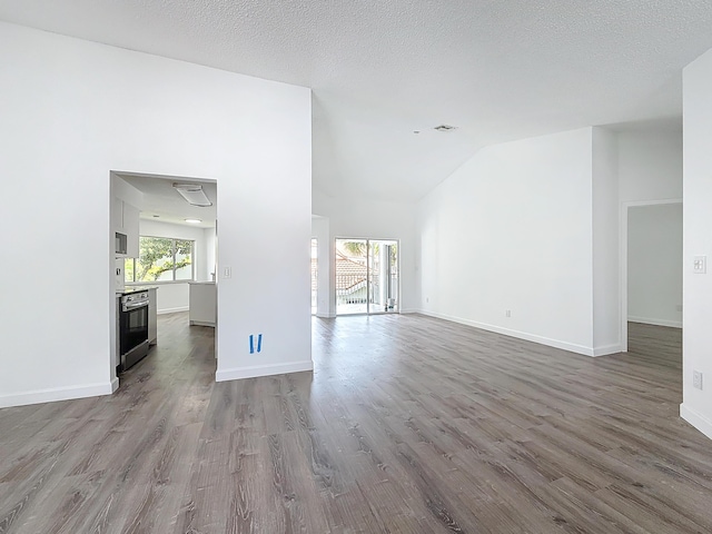 unfurnished living room with high vaulted ceiling, a textured ceiling, baseboards, and wood finished floors