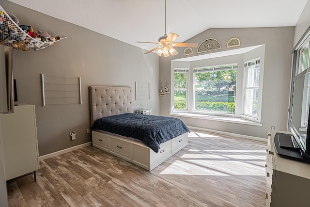 bedroom with baseboards, vaulted ceiling, light wood finished floors, and ceiling fan