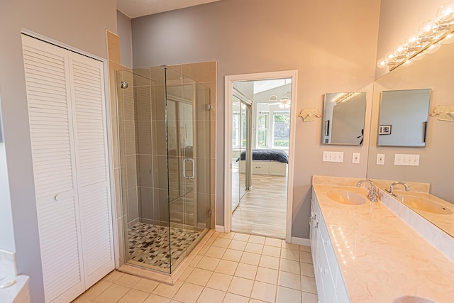 ensuite bathroom with double vanity, a closet, and a sink