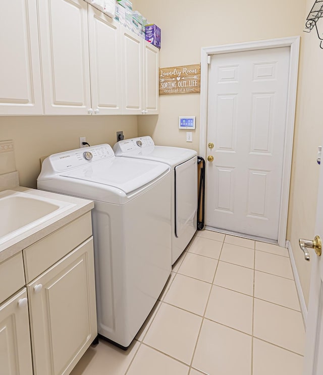 laundry area with cabinet space, washing machine and dryer, and light tile patterned floors