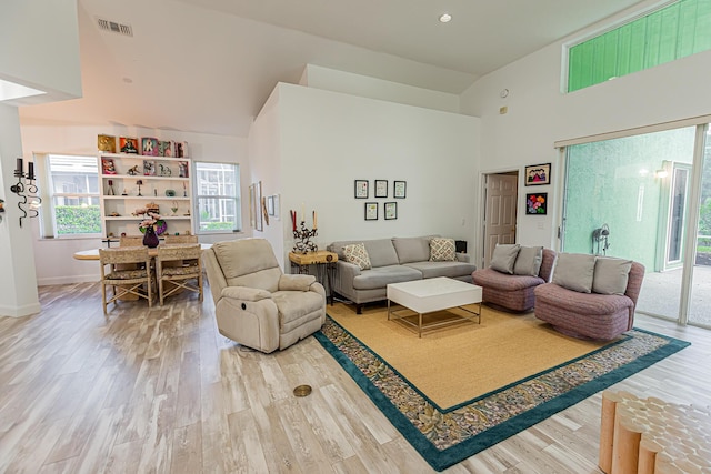 living room featuring high vaulted ceiling, a healthy amount of sunlight, visible vents, and wood finished floors