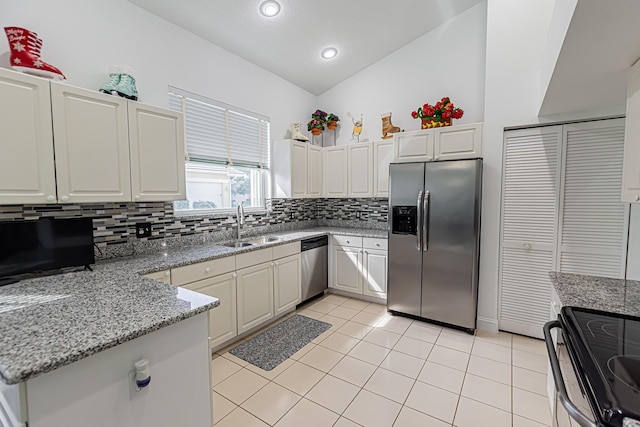 kitchen with light tile patterned floors, light stone counters, a sink, stainless steel appliances, and backsplash